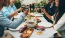 a group of people having a meal around an outdoor table